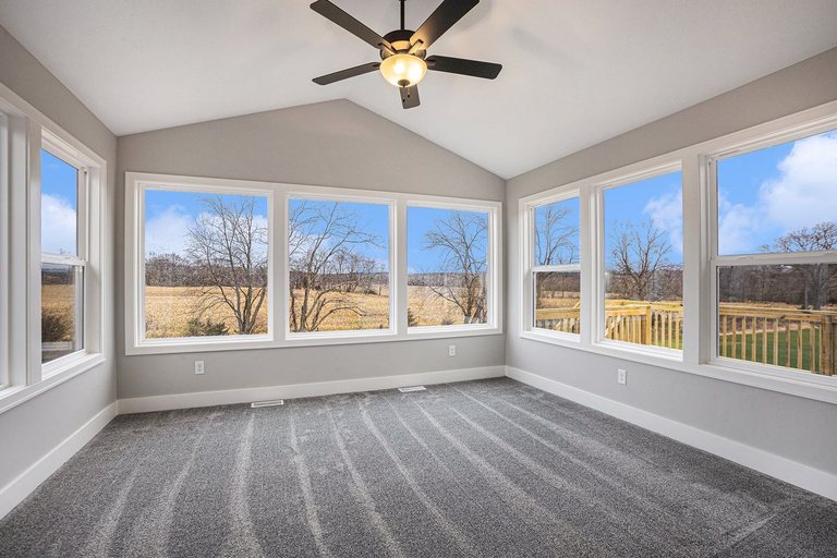 Vaulted sunroom addition with carpet and views of open fields — MDR Design-Build-Remodel