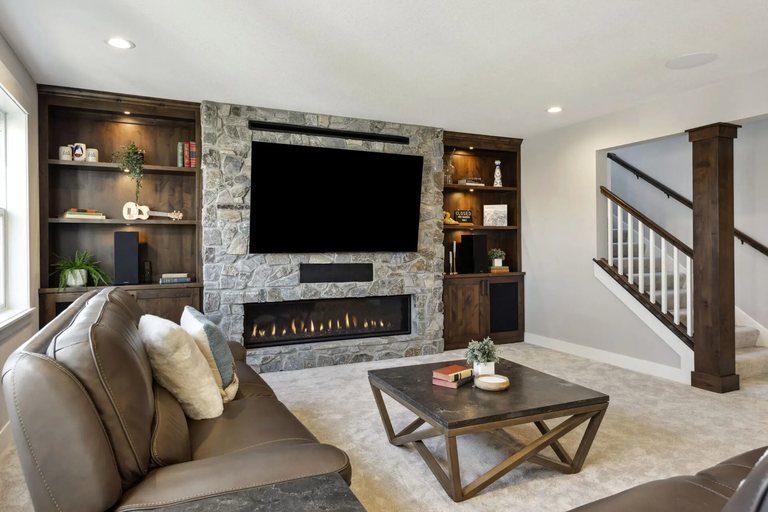 Finished basement with a stone fireplace by MDR Design-Build-Remodel