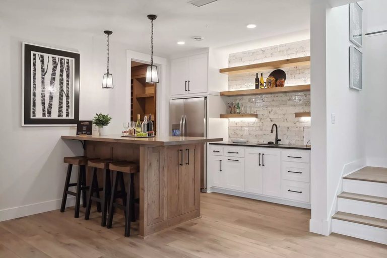 Basement bar with a live-edge wood island and counter seating — MDR Design-Build-Remodel