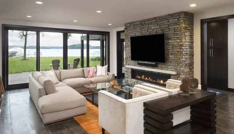 Walkout basement with a stone fireplace and lake views — MDR Design-Build-Remodel
