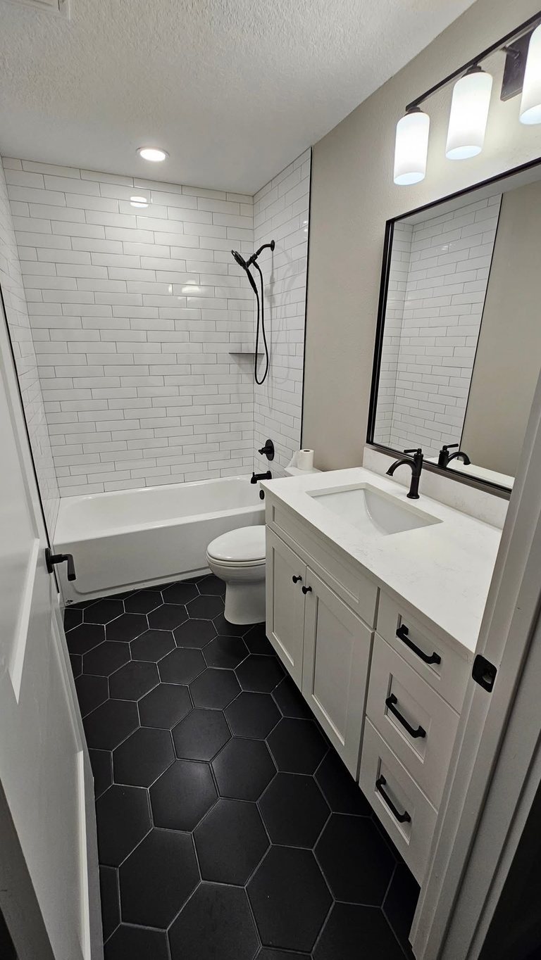 Bathroom remodel with black hexagon floor tile and a tub-and-shower combo — MDR Design-Build-Remodel