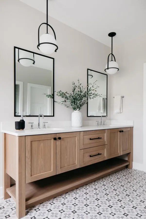 Bathroom with a wood double vanity, brass fixtures, and patterned tile floor — MDR Design-Build-Remodel