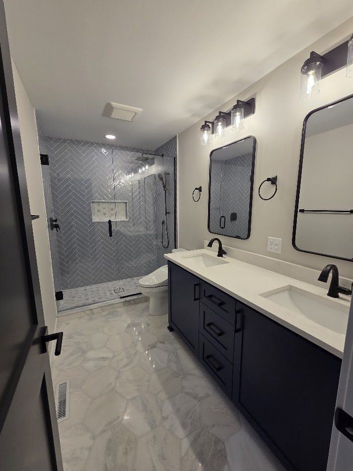 Bathroom with a navy vanity and a tiled walk-in shower — MDR Design-Build-Remodel